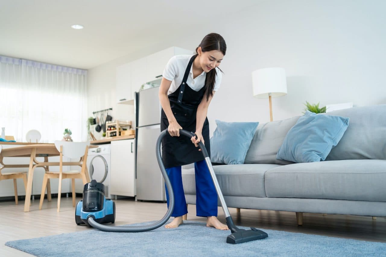 Professional cleaner working in a living room at home
